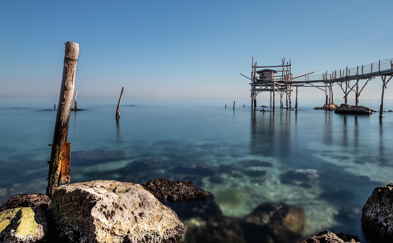 Spiaggia nascosta sulla costa veneta, con sabbia dorata e acque cristalline circondate da scogliere.