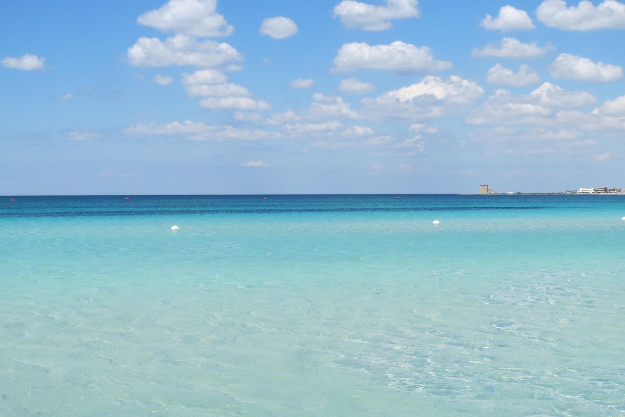 Spiaggia della Sardegna occidentale con acqua cristallina e sabbia bianca, ideale per una giornata di relax.