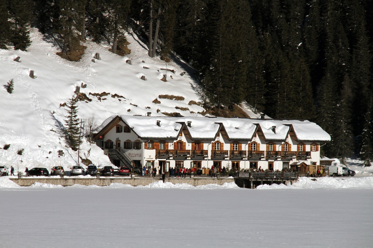 Vista panoramica del Lago di Braies con montagne e boschi circostanti, ideale per una gita spettacolare.