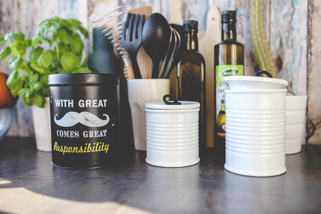 Contenitori salvaspazio per cucina, vari modelli e colori, su un ripiano ordinato e pulito.