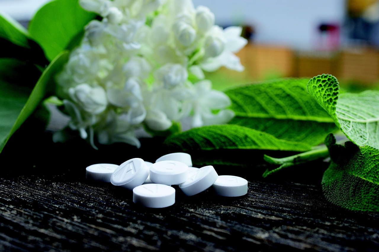 Aspirina disciolta in un bicchiere d'acqua accanto a piante verdi.