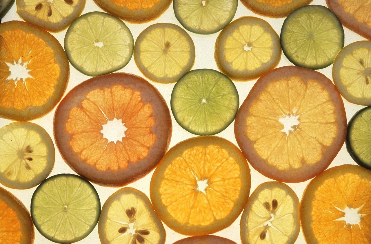 Donna che osserva agrumi, simbolo della vitamina C e dei suoi benefici per la salute.