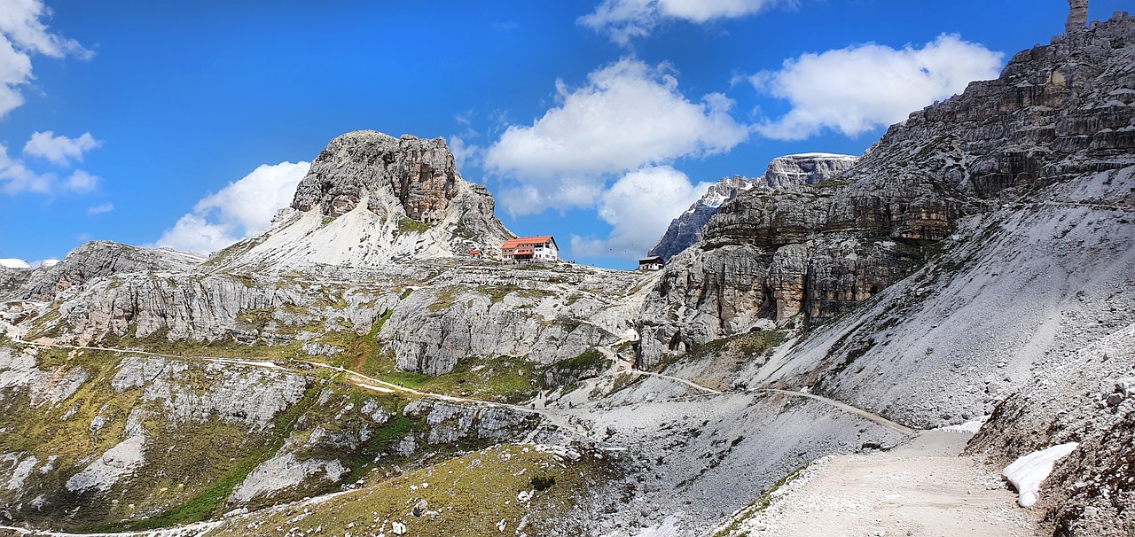 Escursionista su una via ferrata panoramica nelle Dolomiti, circondato da maestose montagne.