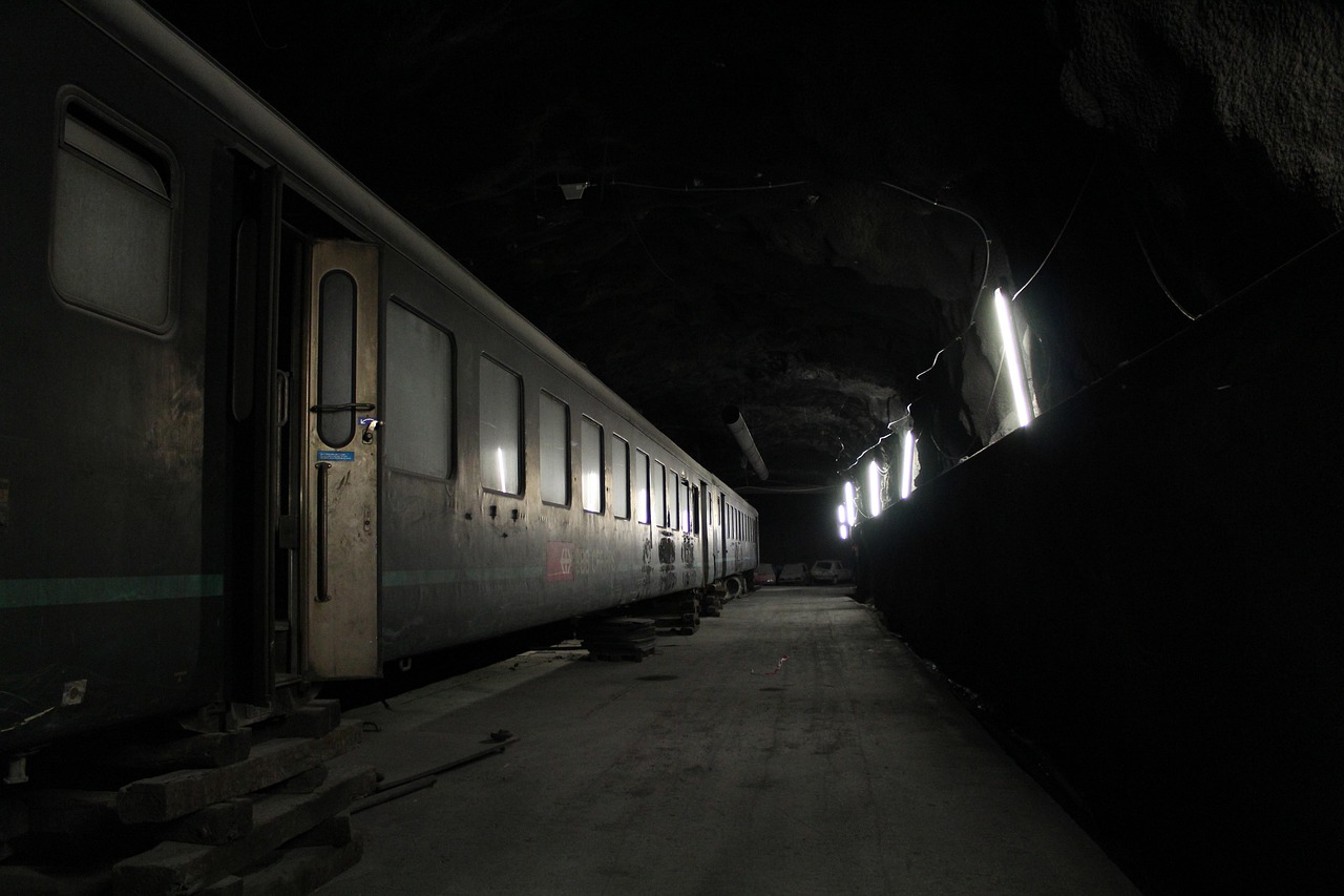 Treno minerario storico in movimento nelle ferrovie del Sulcis, attrazione turistica unica.
