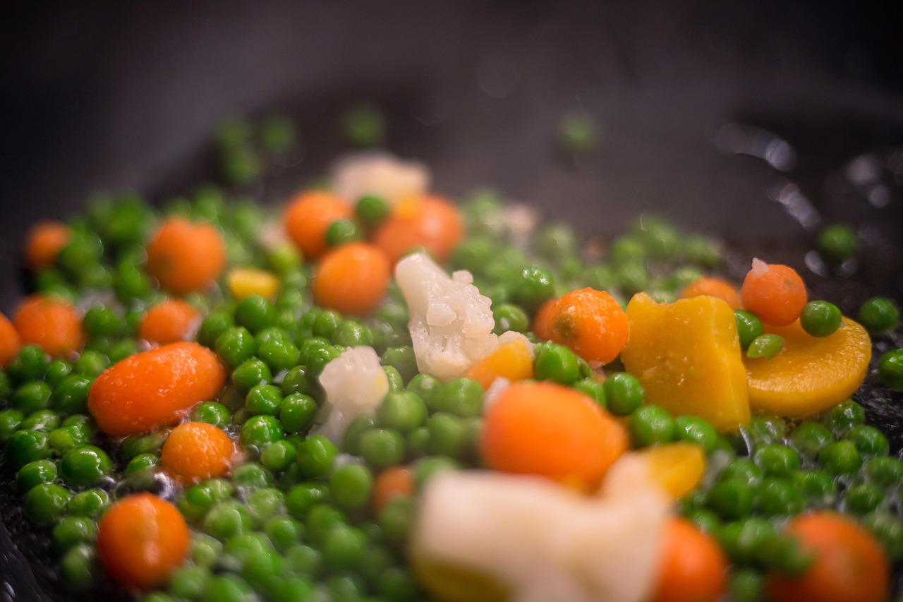 Verdure riscaldate su un piatto, evidenziando la loro consistenza morbida e il colore vivace.